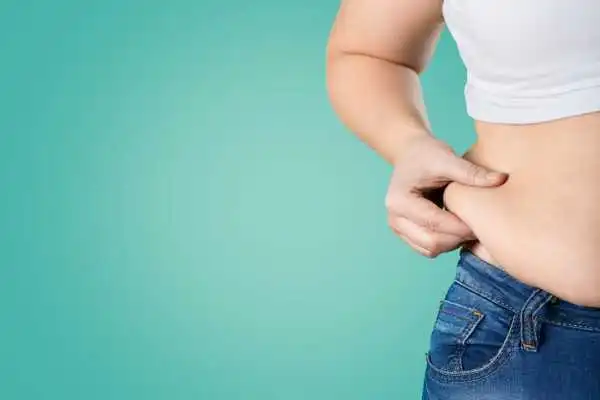 Image of woman pinching her love handles to show weight gain Hassocks